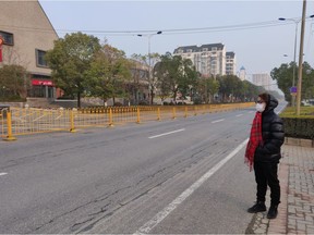 Edward Yuan, 28, of Vancouver stands on deserted street around 8 a.m. Jan. 29, 2020 in Wuhan, the city of 11 million that has been turned into a ghost town, thanks to a travel ban to try to contain the coronavirus flu outbreak.