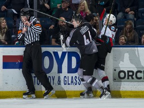 Bowen Byram of the Vancouver Giants checks Pavel Novak of the Kelowna Rockets into the boards during first period at Prospera Place Sunday.