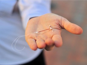 Holding an IUD birth control copper coil device in hand, used for contraception