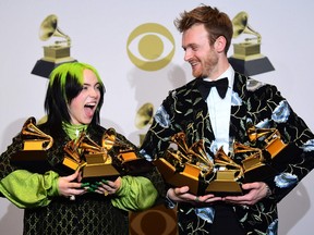U.S. singer-songwriter Billie Eilish (L) and Finneas O'Connell pose in the press room with the awards for Album Of The Year, Record Of The Year, Best New Artist, Song Of The Year and Best Pop Vocal Album during the 62nd Annual Grammy Awards on January 26, 2020, in Los Angeles.