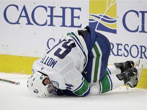 Vancouver Canucks' Tyler Motte falls to the ice after a hit by Erik Karlsson during the second period of the team's NHL hockey game against the San Jose Sharks on Wednesday, Jan. 29, 2020, in San Jose, Calif. Motte left the game with an injury.