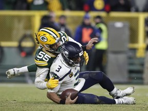 Jan 12, 2020; Green Bay, WI, USA; Seattle Seahawks quarterback Russell Wilson (3) is tackled by Green Bay Packers outside linebacker Za'Darius Smith (55) in the third quarter of a NFC Divisional Round playoff football game at Lambeau Field. Mandatory Credit: Jeff Hanisch-USA TODAY Sports