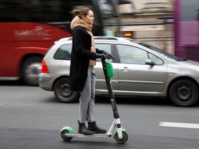 A woman rides a dock-free electric scooter or "trotinette" Lime-S by California-based bicycle sharing service Lime in a street of Paris as a strike by all unions of the Paris transport network (RATP) and French SNCF workers entered its 16th consecutive day in Paris, France, December 20, 2019.