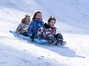 Here's a handy list of the schools around Metro Vancouver that have reported closures. Sam Wozny, Isabella Wozny and Lily Greer take advantage of a snow day by going sledding at QE Park in Vancouver, B.C. in this 2019 file photo.