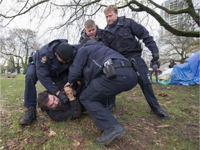 FILE PHOTO -Ivan Drury is taken away by VPD from a tent city set up at Thornton Park in Vancouver, B.C., November 25, 2016.