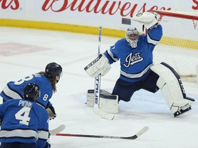 Connor Hellebuyck makes a glove save during shutout performance Tuesday.