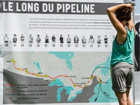 A passerby looks at a map of the proposed Energy East pipeline in Quebec.