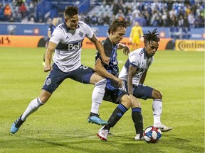 Montreal Impact's Lassi Lappalainen splits Vancouver Whitecaps Jakob Nerwinski (left) and Yordy Reyna an August 2019 Major League Soccer match in Montreal.