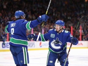Canucks defence pairing Chris Tanev and Quinn Hughes celebrates Tanev's goal against the Los Angeles Kings during an Oct. 9, 2019 NHL game at Rogers Arena.