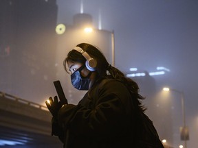 A Chinese woman wears a protective mask as she waits for a bus at a usually busy stop on February 13, 2020 in Beijing, China. The number of cases of the deadly new coronavirus COVID-19 rose to more than 52000 in mainland China Thursday, in what the World Health Organization (WHO) has declared a global public health emergency. China continued to lock down the city of Wuhan in an effort to contain the spread of the pneumonia-like disease which medicals experts have confirmed can be passed from human to human. In an unprecedented move, Chinese authorities have maintained and in some cases tightened the travel restrictions on the city which is the epicentre of the virus and also in municipalities in other parts of the country affecting tens of millions of people. The number of those who have died from the virus in China climbed to over 1300 on Thursday, mostly in Hubei province, and cases have been reported in other countries including the United States, Canada, Australia, Japan, South Korea, India, the United Kingdom, Germany, France and several others. The World Health Organization has warned all governments to be on alert and screening has been stepped up at airports around the world. Some countries, including the United States, have put restrictions on Chinese travellers entering and advised their citizens against travel to China.