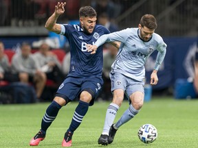 Ilie Sanchez #6 of Sporting Kansas City tries to keep Lucas Cavallini #9 of the Vancouver Whitecaps away from the ball during MLS soccer action at BC Place on February 29, 2020 in Vancouver, Canada.