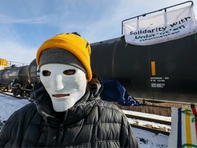 Canadian Pacific Railway Ltd. is the latest victim of rail blockades taking place across the country as protests against the construction of a B.C. natural gas pipeline enter a third week. In this file photo, a supporter of the indigenous Wet'suwet'en Nation wears a mask, joining others occupying railway tracks as part of a protest against British Columbia's Coastal GasLink pipeline, in Toronto, Ontario, Canada February 15, 2020.