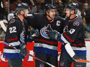 Daniel and Henrik Sedin flank Canucks captain Markus Naslund in a post-goal celebration during the 2006-07 NHL season.