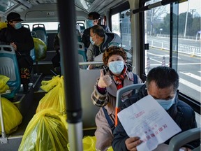This photo taken on February 22, 2020 shows people who have recovered from the COVID-19 coronavirus infection leaving a hospital by bus in Wuhan in China's central Hubei province. Chinese authorities on February 24 slightly relaxed their month-long quarantine measures in Wuhan, allowing some people to leave the epicentre of the country's virus epidemic under certain conditions.