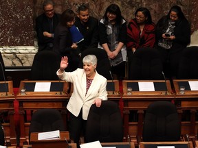 Finance Minister Carole James waves to people in the gallery at the legislature in Victoria.