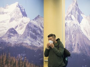 A passenger wears a mask in the international arrivals area at Vancouver International Airport on Jan. 23. The World Health Organization is contemplating whether to declare a global health emergency because of coronavirus, or COVID-19.