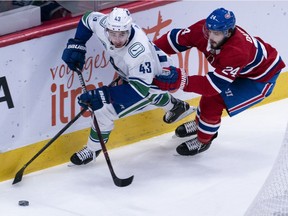 Defenceman Quinn Hughes of the Vancouver Canucks is chased by Montreal Canadiens' Phillip Danault during NHL action in Montreal on Feb. 25.