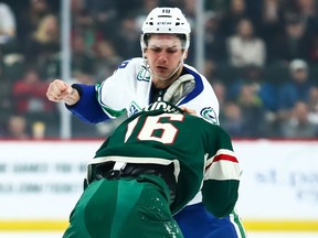 Vancouver Canucks right wing Jake Virtanen (18) and Minnesota Wild left wing Jason Zucker (16) fight in the first period at Xcel Energy Center.