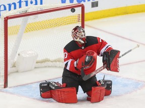Louis Domingue looks for the puck after making a stop for the Devils on Feb. 11.