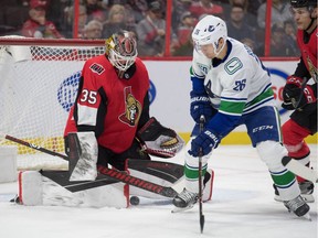 Senators goalie Marcus Hogberg (35) makes a save on a shot from Vancouver Canucks left wing Antoine Roussel (26) in the first period at the Canadian Tire Centre.