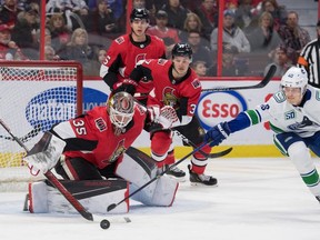 Senators' netminder Marcus Hogberg makes a save in front of Vancouver Canucks' centre Elias Pettersson during Thursday's NHL action at the Canadian Tire Centre in Ottawa.