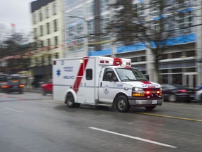 An ambulance races down E. Hastings Street in Vancouver.