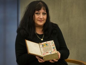Michelle Greig holds a circa-1430 Brevarium at Vancouver Public Library in Vancouver.