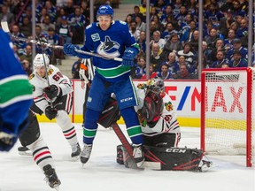 Canucks winger Justin Bailey sets a screen on Blackhawks goalie Corey Crawford last season.