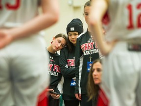 Alanna Noble leans her head on Terry Fox secondary’s Karin Khuong during a break in play at the B.C. high school girls basketball provincial championships at the Langley Events Centre in February.