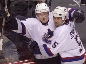 Winger Daniel Sedin (left) celebrates a Canucks goal with defenceman Ed Jovanovski during a game in the 2001-02 NHL season.