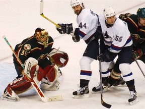 Vancouver Canucks Todd Bertuzzi and Ed Jovanovski stake out territory in front of Minnesota Wild goalie Dwayne Roloson during Game 5 of the Western Conference semi-finals at GM Place in Vancouver on May 5, 2003.