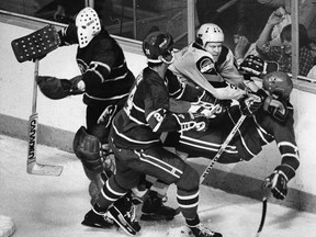Montreal Canadiens goalie Bunny Larocque hurries back to his net while Vancouver Canucks Lars Lindgren bowls over Canadiens Brian Engblom while teammate Gilles Lupien works on Lindgren with his stick during NHL action at the Pacific Coliseum, filed Jan. 30, 1980.