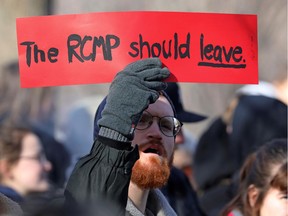 A supporter of the indigenous Wet'suwet'en Nation holds a sign before a march, as part of a protest against British Columbia's Coastal GasLink pipeline in Toronto on February 17, 2020.