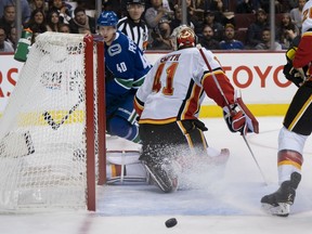 Elias Pettersson watches the puck exit the net past Calgary Flames goalie Mike Smith after the Canucks centre scored the first regular season goal of his NHL career on a laser wrist shot — his first shot in his first game — on Oct. 3, 2018 at Rogers Arena.