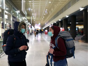 Two Portuguese passengers wearing a protective mask whom got trapped in Venice at the establishment of the quarantine are seen at the Venice Santa Lucia train Station trying to understand how to leave the city on March 8, 2020 in Venice, Italy. Prime Minister Giuseppe Conte announced overnight a "national emergency" due to the coronavirus outbreak and imposed quarantines on the Lombardy and Veneto regions, which contain roughly a quarter of the country's population. Italy has the highest number of cases and fatalities in Europe.