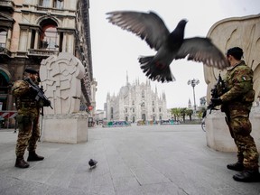 Italian soldiers patrol as the Duomo gothic cathedral is visible in background, in Milan, Friday, March 20, 2020. Mayors of many towns in Italy are asking for ever more stringent measures on citizens' movements to help contain the surging infections of the coronavirus. For most people, the new coronavirus causes only mild or moderate symptoms. For some it can cause more severe illness.