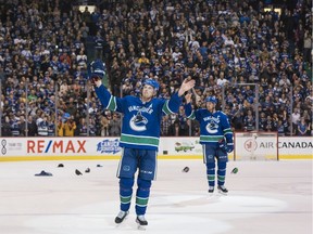 Daniel Sedin and Henrik Sedin, right, of the Vancouver Canucks salute the fans after playing in the final home game of their NHL careers on April 5, 2018 at Rogers Arena in Vancouver.