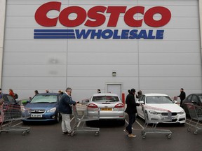 Customers wait in a long queue to enter a Costco.
