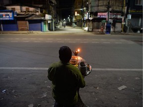A vendor selling snacks waits for customers in a deserted area of Siliguri, India, after the authorities imposed a lockdown.