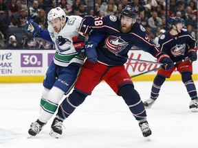 Vancouver Canucks' Tyler Motte, left, and Columbus Blue Jackets' David Savard fight for position during the first period of an NHL hockey game Sunday, March 1, 2020, in Columbus, Ohio.