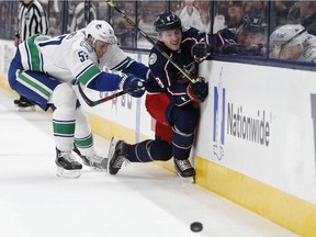Tyler Myers of the Vancouver Canucks squashed Zach Werenski  of the Columbus Blue Jackets into the boards when the teams played on March 1 in Columbus, Ohio.