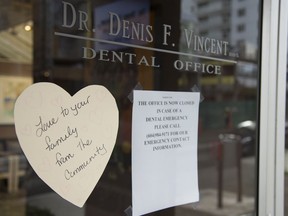 A note from the community is seen on the front door of Dr. Denis Vincent's dental practice in North Vancouver, B.C. Tuesday, March 31, 2020. Dr. Denis Vincent was British Columbia's first community death from the novel coronavirus.