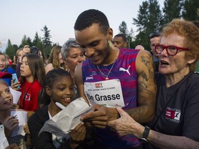 Canadian sprint star Andre De Grasse signs autographs after running the men's 100-metre race at the 2017 Vancouver Sun Harry Jerome Track Classic.