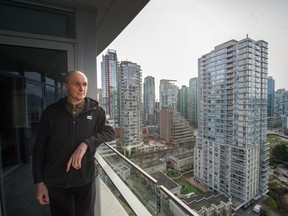 Ian Gilhooley stands on the balcony of his condo on West Cordova street in Vancouver, B.C., March 4, 2020. Saturday feature about skyrocketing cost of condo insurance and the many people affected.