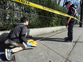 Workers paint yellow lines on the sidewalk to prevent the spread of Covid-19 in the lineup at The Door Is Open soup kitchen on Dunlevy St, in Vancouver BC., March 25, 2020.  (NICK PROCAYLO/PNG)   00060828A ORG XMIT: 00060831A [PNG Merlin Archive]