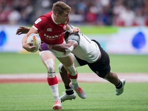 Canada's Theo Sauder, front, looks to pass while being tackled by Fiji's Vilimoni Botitu during the Canada Sevens rugby tournament in Vancouver, on Saturday, March 7, 2020.