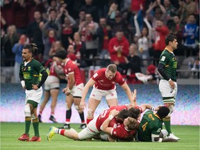 Canada's Jake Thiel (13) is mobbed by his teammates after Canada defeated South Africa during the bronze medal match at the Canada Sevens rugby tournament in Vancouver, on Sunday, March 8, 2020.