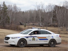 An RCMP vehicle is parked near the rubble of a destroyed home linked to Sunday's deadly shooting rampage in Wentworth Centre, Nova Scotia.