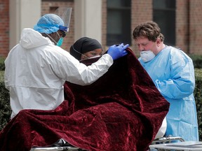 Healthcare workers prepare to transfer the body of a deceased person at Kingsbrook Jewish Medical Center during the outbreak of the coronavirus disease (COVID19) in the Brooklyn borough of New York, U.S., April 8, 2020.