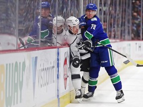 Michael Ferland of the Vancouver Canucks bangs Dustin Brown of the Los Angeles Kings into the boards during an NHL game in Vancouver on Oct. 9, 2019.